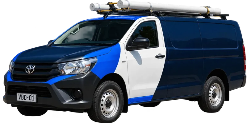 A licensed Campbelltown plumbing van loaded with pipe on the roof rack